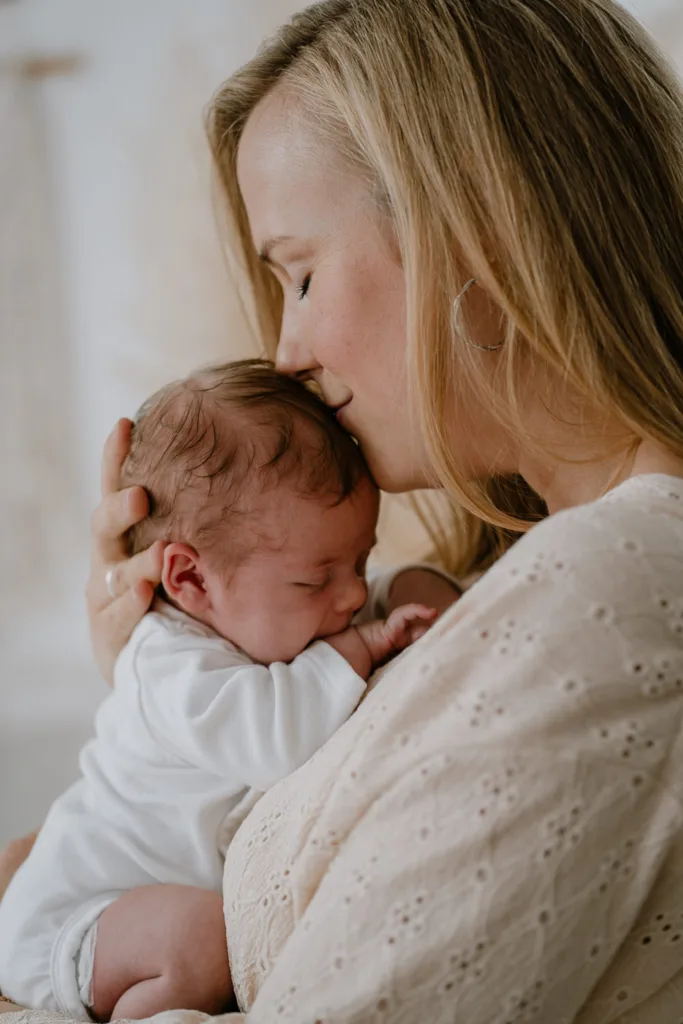 Neugeborenenshooting-Mama küsst Baby auf Hinterkopf
