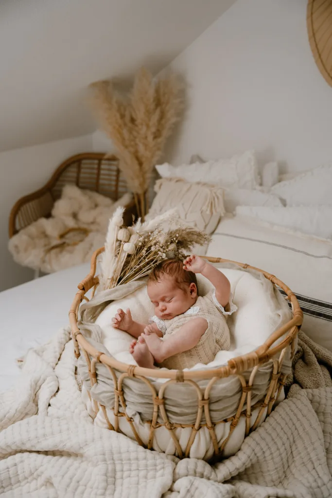 Neugeborenenshooting-Baby liegt in Korb und wird fotografiert