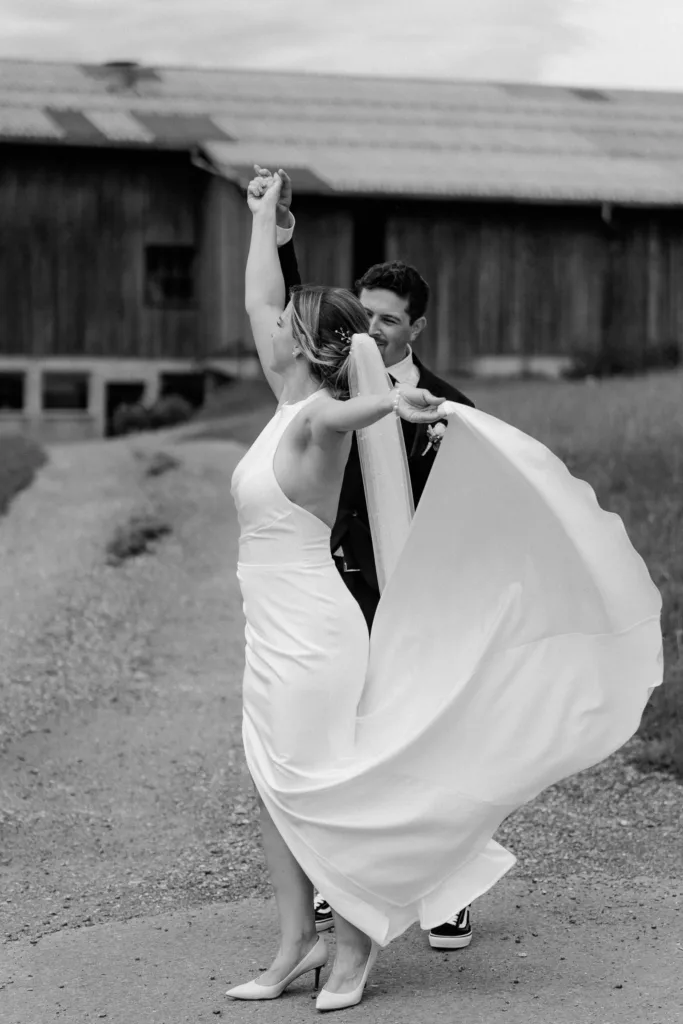 Schwarzweißes Hochzeitsfoto einer tanzenden Braut mit fließendem Kleid bei einer Hochzeit in Österreich.