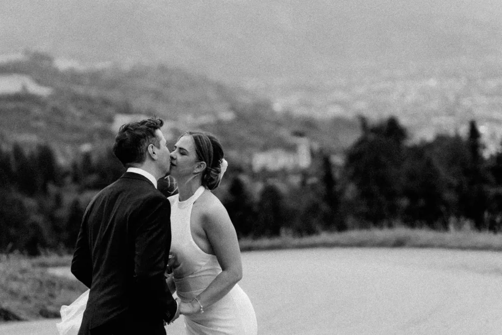 Schwarzweißes Brautpaarfoto bei einer Berghochzeit in Österreich mit weiter Landschaft im Hintergrund.