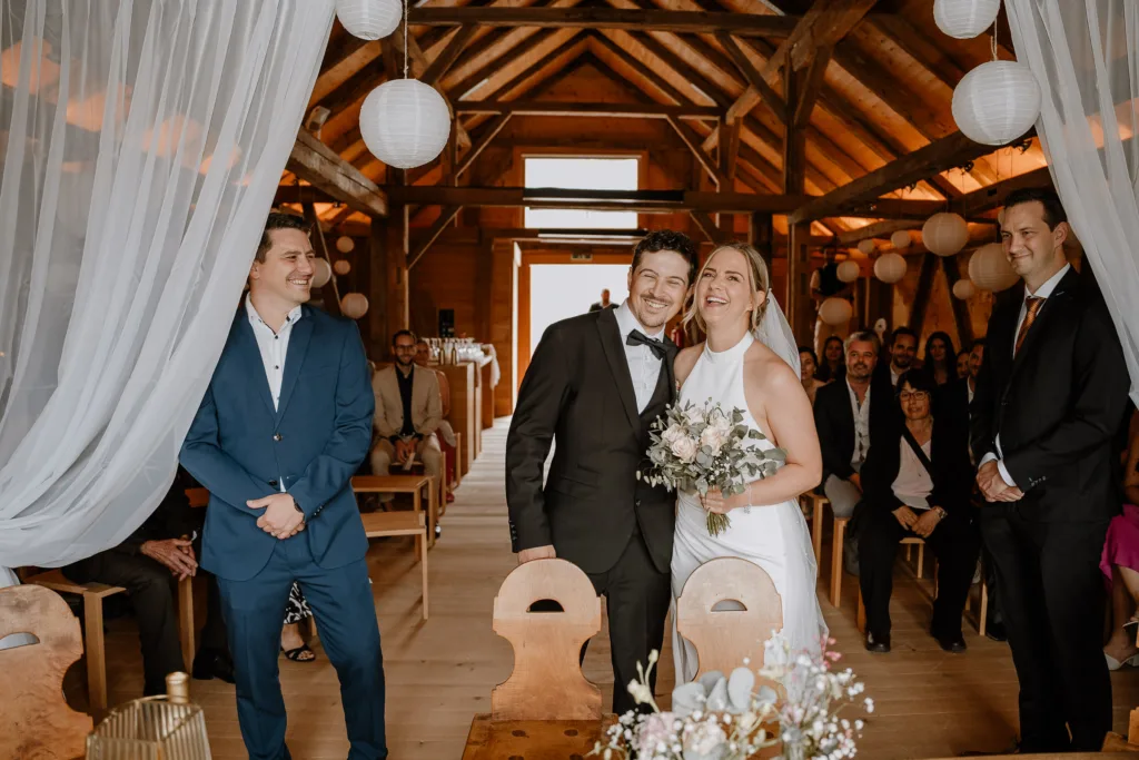 Braut und Bräutigam halten sich während der Trauung in den Armen und lachen