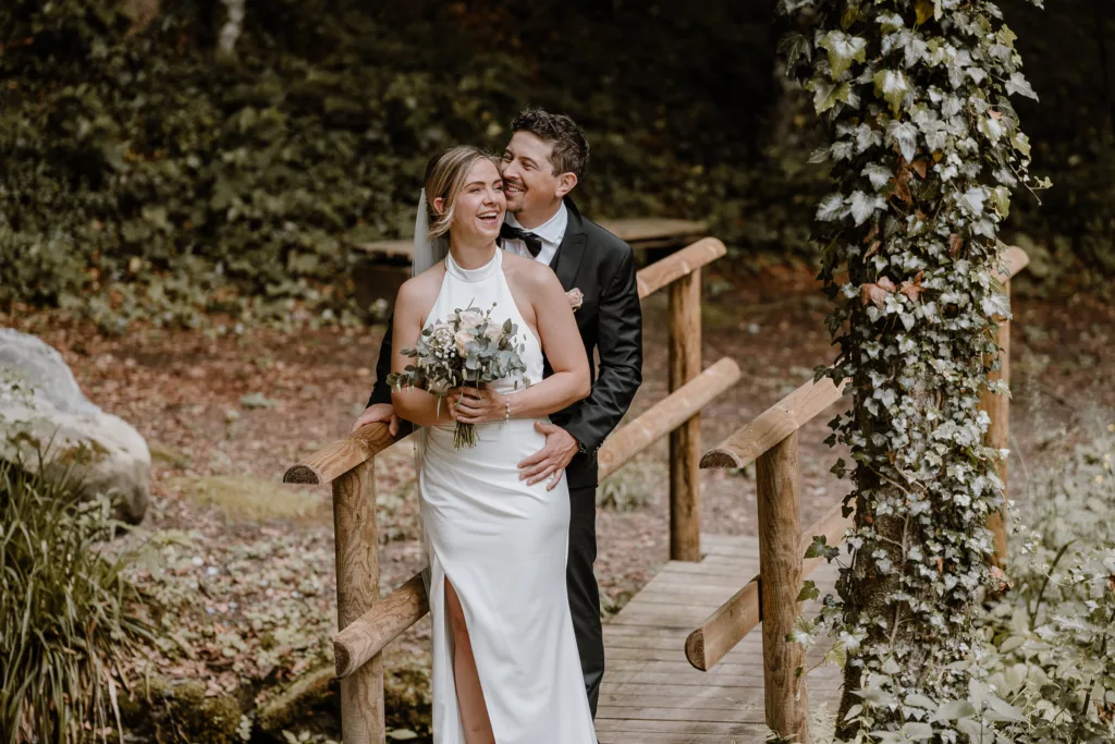Modernes Brautpaarportrait bei einer Berghochzeit in Österreich mit natürlichem Licht und Waldkulisse.