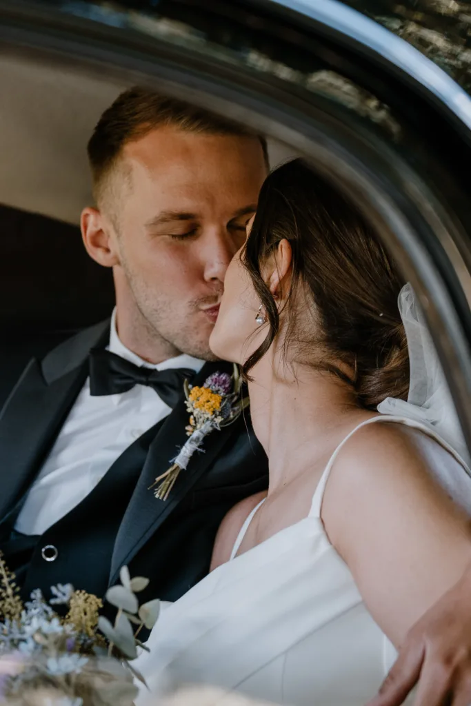 Intimes Portrait des Brautpaares im Hochzeitsauto