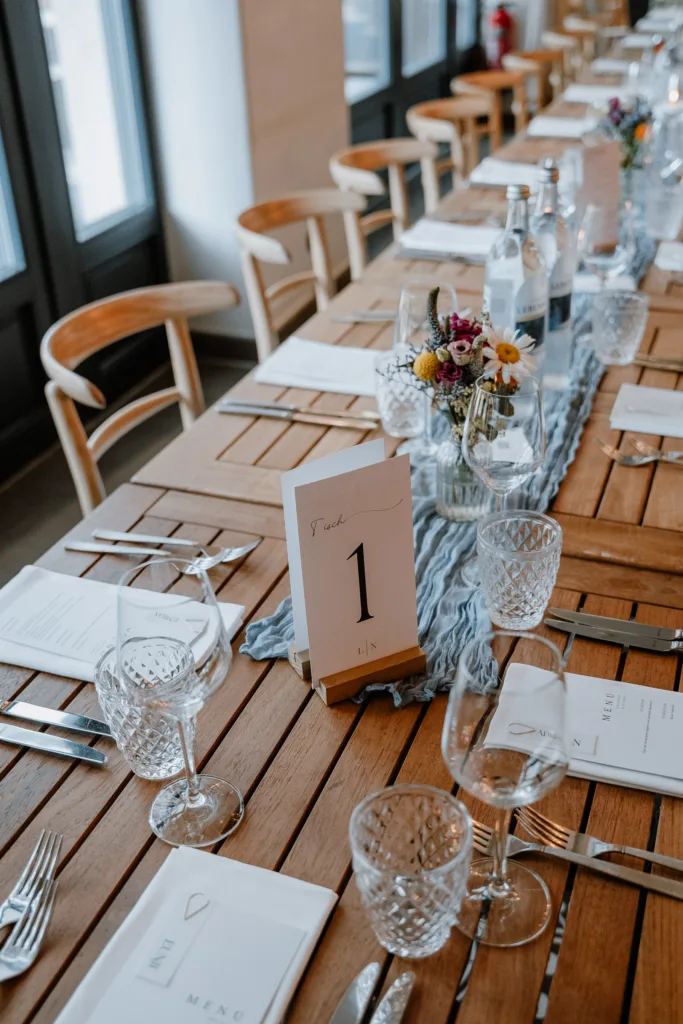 Festlich gedeckter Hochzeitstisch mit Tischnummer und Blumen