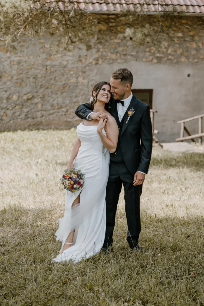 Brautpaar steht eng beieinander und lächelt sich an