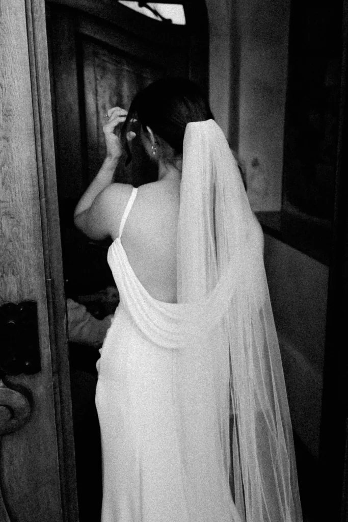 Schwarzweißaufnahme der Braut von hinten mit langem Schleier