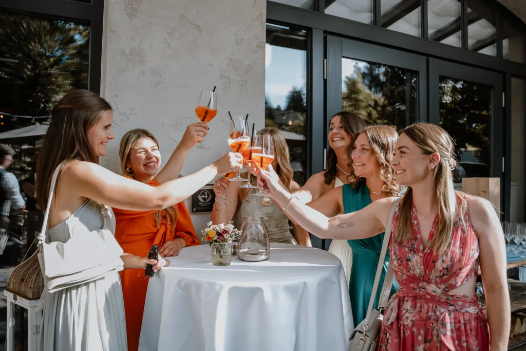 Hochzeitsgäste stoßen draußen mit Aperol Spritz an